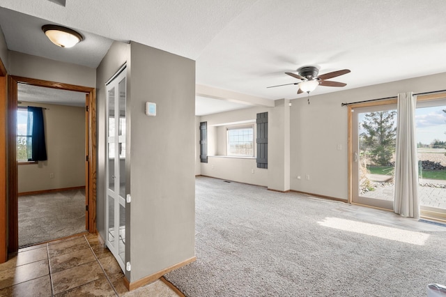 empty room featuring carpet floors, baseboards, and a ceiling fan
