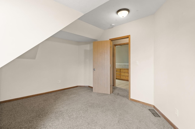 bonus room featuring baseboards, visible vents, and light carpet