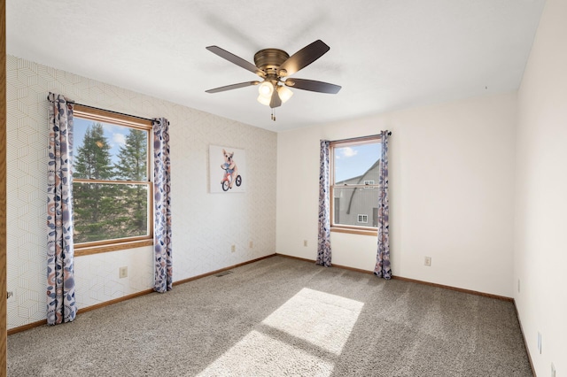 spare room with baseboards, carpet flooring, and a ceiling fan