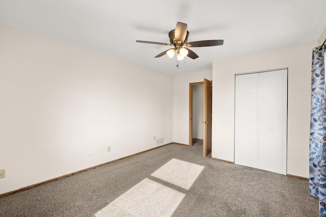 unfurnished bedroom featuring carpet flooring, ceiling fan, baseboards, visible vents, and a closet