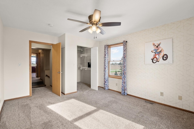 unfurnished bedroom featuring carpet floors, baseboards, a closet, and visible vents