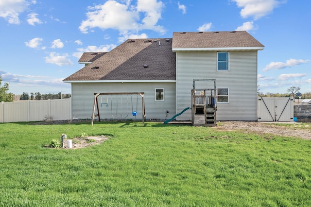back of property with a playground, a gate, a fenced backyard, and roof with shingles