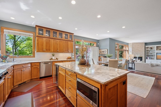 4970 Yuma Ct N, Plymouth, MN 55446 - kitchen with stainless steel appliances, a kitchen island, light stone counters, brown cabinetry, and recessed lighting