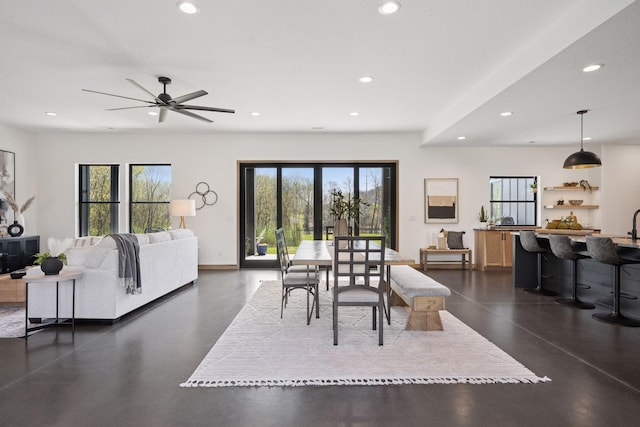 dining room with ceiling fan, finished concrete flooring, baseboards, and recessed lighting