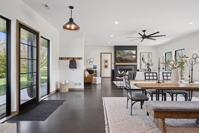 dining space featuring a fireplace, a healthy amount of sunlight, and recessed lighting