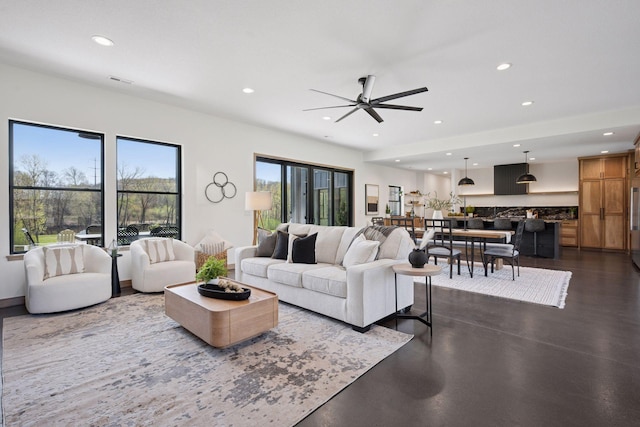 living room featuring finished concrete floors, visible vents, ceiling fan, and recessed lighting