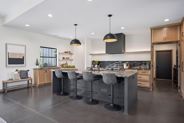 kitchen featuring light stone countertops, a breakfast bar area, recessed lighting, a sink, and open shelves