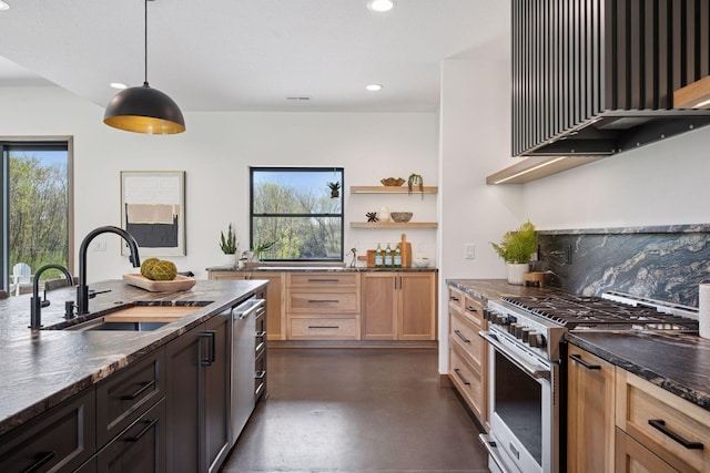 kitchen featuring a sink, stainless steel appliances, wall chimney range hood, a wealth of natural light, and finished concrete flooring