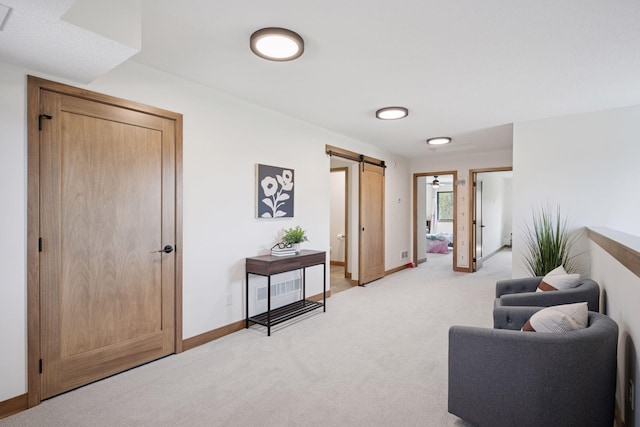 interior space with baseboards, light carpet, and a barn door