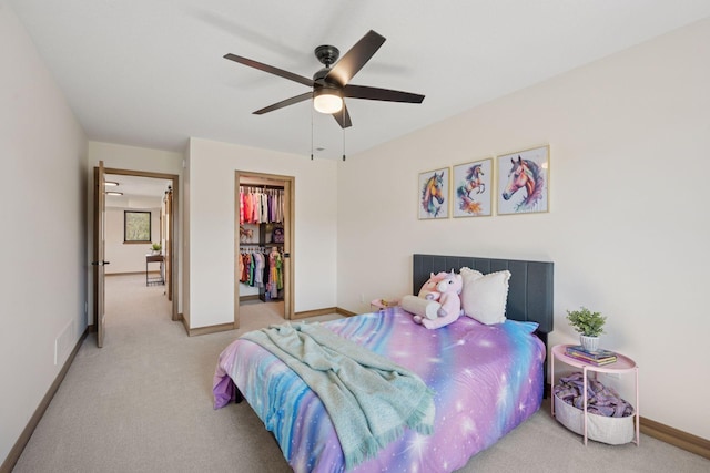 bedroom with carpet, a closet, a walk in closet, visible vents, and baseboards