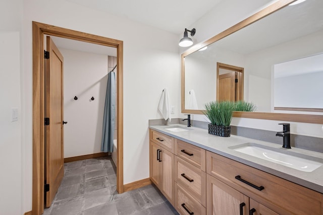 full bathroom featuring a sink, double vanity, shower / tub combo with curtain, and baseboards