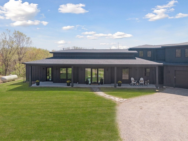 view of property's community with dirt driveway, a patio, and a lawn