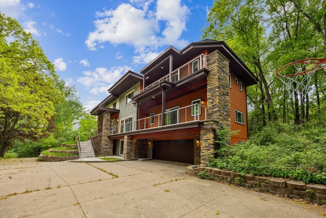 21 Red Fox Rd, North Oaks, MN 55127 - view of front of home featuring a balcony, a garage, stone siding, concrete driveway, and stairway