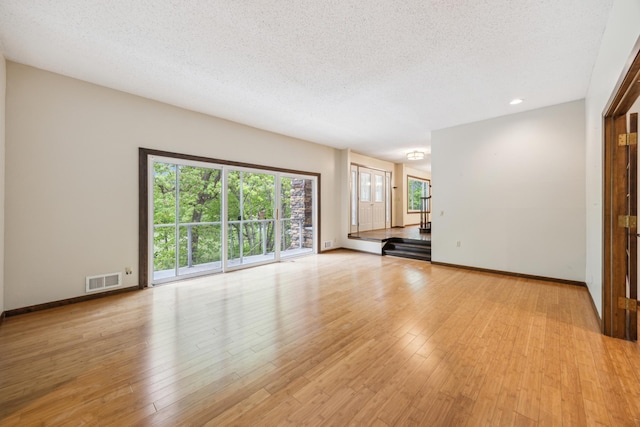 21 Red Fox Rd, North Oaks, MN 55127 - unfurnished living room featuring light wood-type flooring, a textured ceiling, baseboards, and recessed lighting