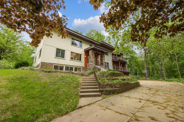 21 Red Fox Rd, North Oaks, MN 55127 - view of front of house featuring stucco siding, stairway, driveway, a front yard, and stone siding