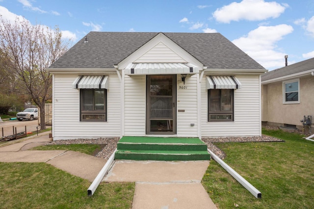bungalow-style home featuring a shingled roof and a front yard