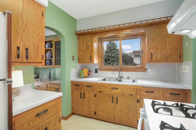 kitchen with light countertops, white range with gas stovetop, a sink, and light floors