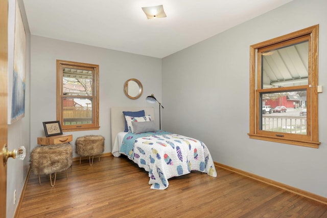 bedroom with baseboards and wood finished floors
