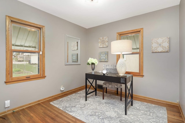 office area with baseboards and wood finished floors