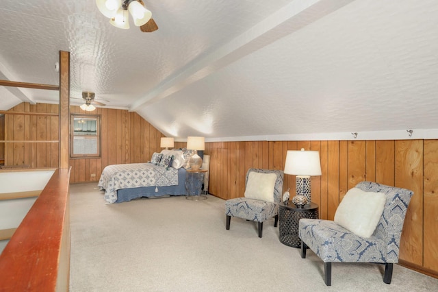 carpeted bedroom with ceiling fan, vaulted ceiling, wood walls, and a textured ceiling