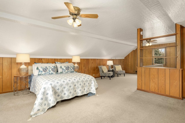 bedroom featuring a ceiling fan, carpet, wooden walls, and vaulted ceiling