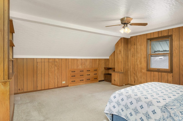 bedroom featuring carpet flooring, ceiling fan, wood walls, and lofted ceiling