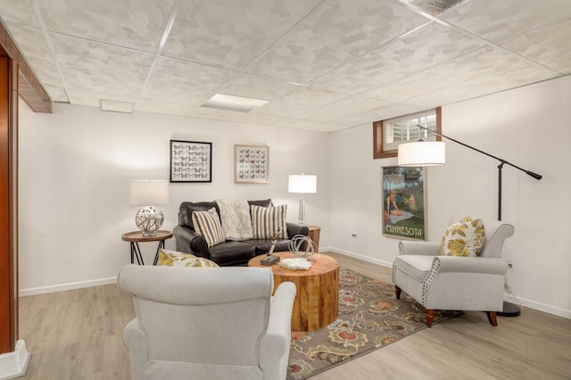living area with baseboards and wood finished floors
