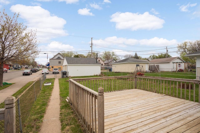 wooden terrace featuring fence, a lawn, and a residential view
