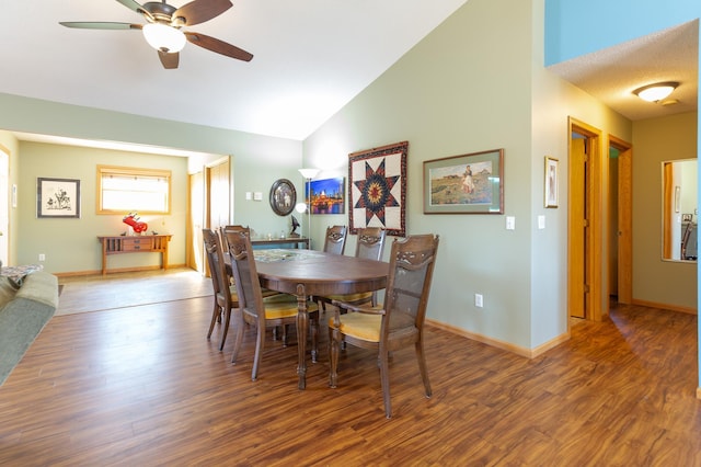 dining area with high vaulted ceiling, ceiling fan, baseboards, and wood finished floors