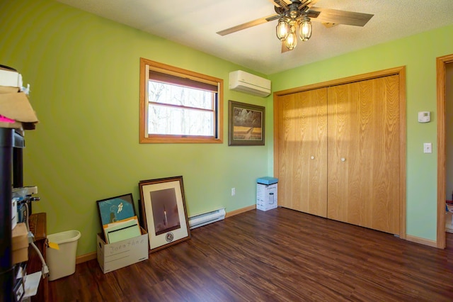 unfurnished bedroom with baseboard heating, an AC wall unit, baseboards, wood finished floors, and a closet