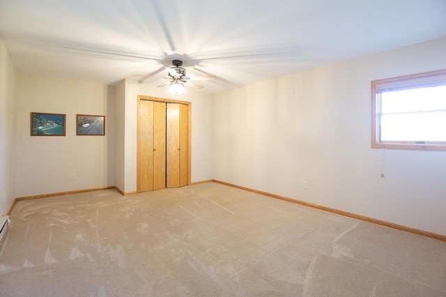 unfurnished bedroom featuring baseboards, light carpet, ceiling fan, and a closet