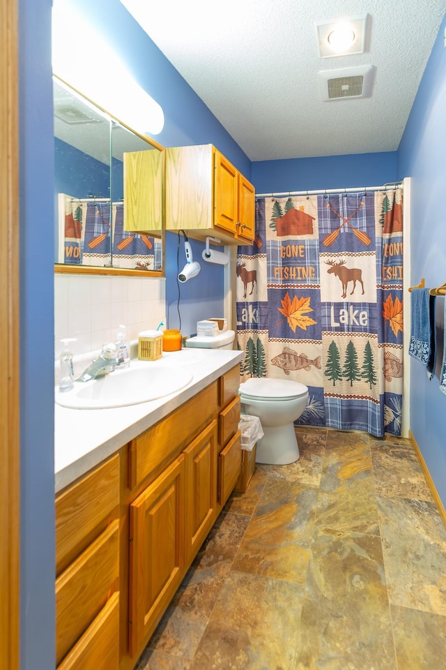 bathroom with visible vents, a textured ceiling, stone finish floor, and toilet