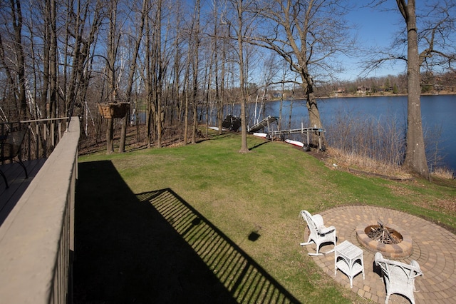 view of yard with a water view, a dock, and a fire pit
