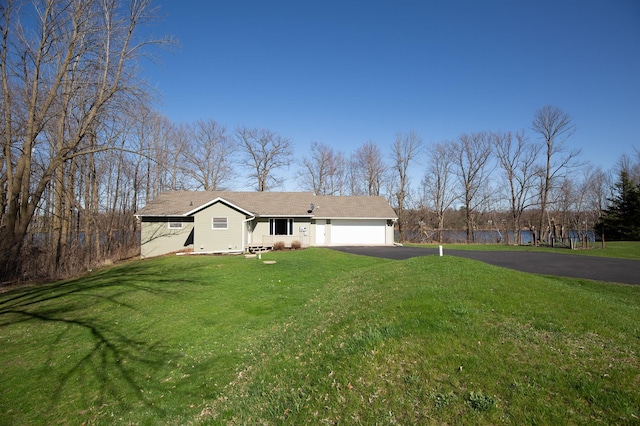 ranch-style house with a garage, a front lawn, aphalt driveway, and a water view