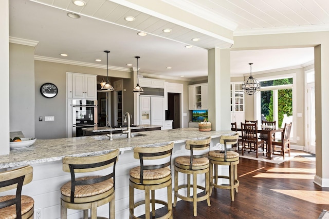 1510 Green Trees Rd, Orono, MN 55391 - kitchen with multiple ovens, dark wood finished floors, a peninsula, ornamental molding, and a kitchen breakfast bar