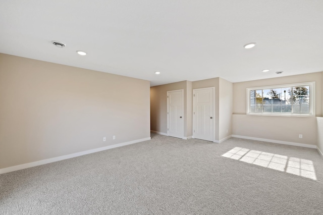 empty room with baseboards, light carpet, and recessed lighting