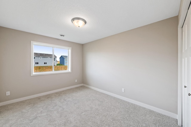 carpeted empty room featuring baseboards