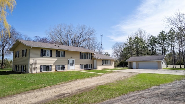 split foyer home featuring an outbuilding, dirt driveway, a garage, and a front yard