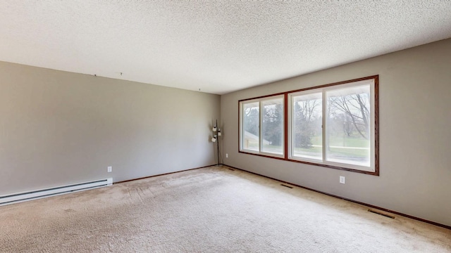carpeted empty room with baseboard heating, a textured ceiling, and baseboards