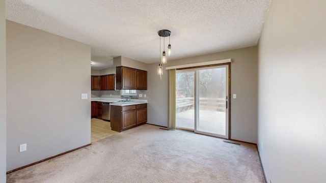 kitchen with dishwasher, light countertops, light carpet, baseboards, and pendant lighting