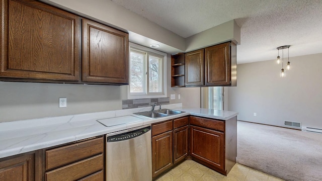 kitchen featuring dishwasher, a sink, a peninsula, light colored carpet, and a textured ceiling