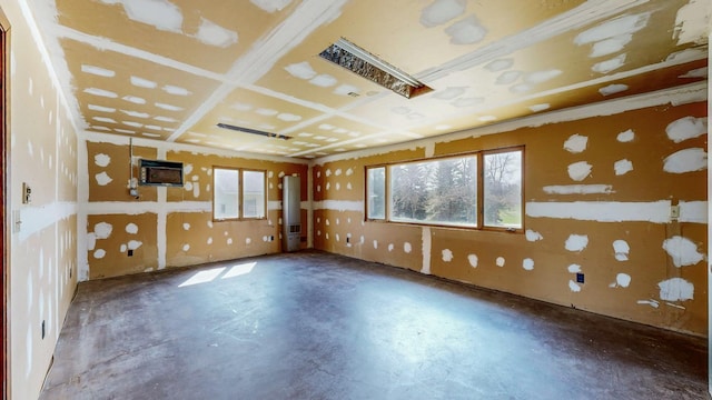 empty room featuring unfinished concrete flooring and a wall mounted AC