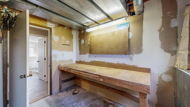 bathroom with unfinished concrete flooring and a workshop area