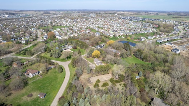 aerial view of property and surrounding area featuring nearby suburban area and a nearby body of water