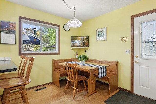 dining area with light wood finished floors and baseboards