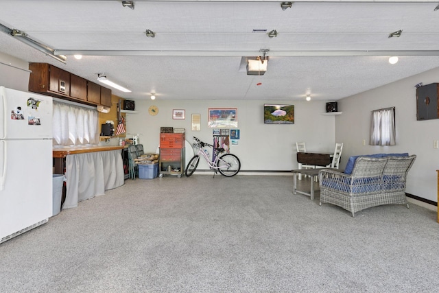 garage featuring freestanding refrigerator, a garage door opener, and baseboards