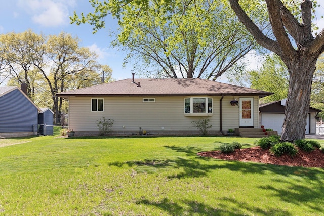 rear view of house featuring an outbuilding, a lawn, entry steps, and a detached garage