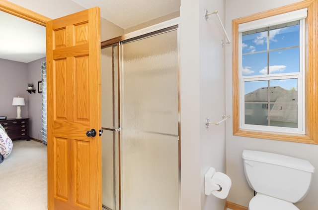full bathroom featuring a stall shower and toilet