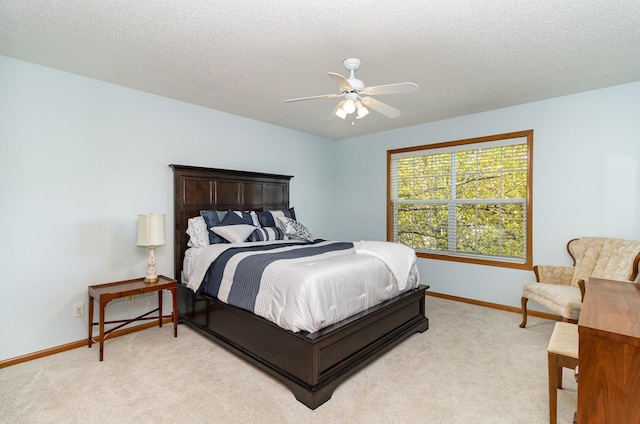 bedroom with light carpet, baseboards, a ceiling fan, and a textured ceiling