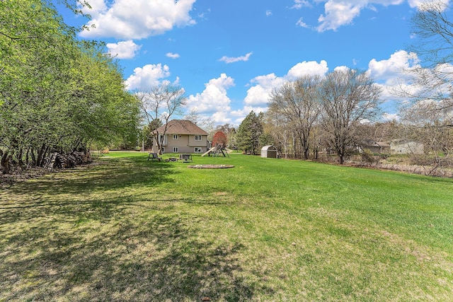 view of yard with a storage shed, an outbuilding, and a playground